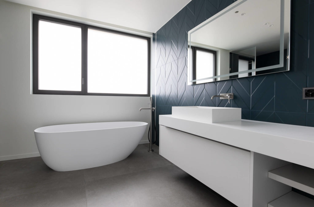 Rénovation d'un salle de bains avec carrelage avec relief en chevron et mobilier de salle de bains blanc